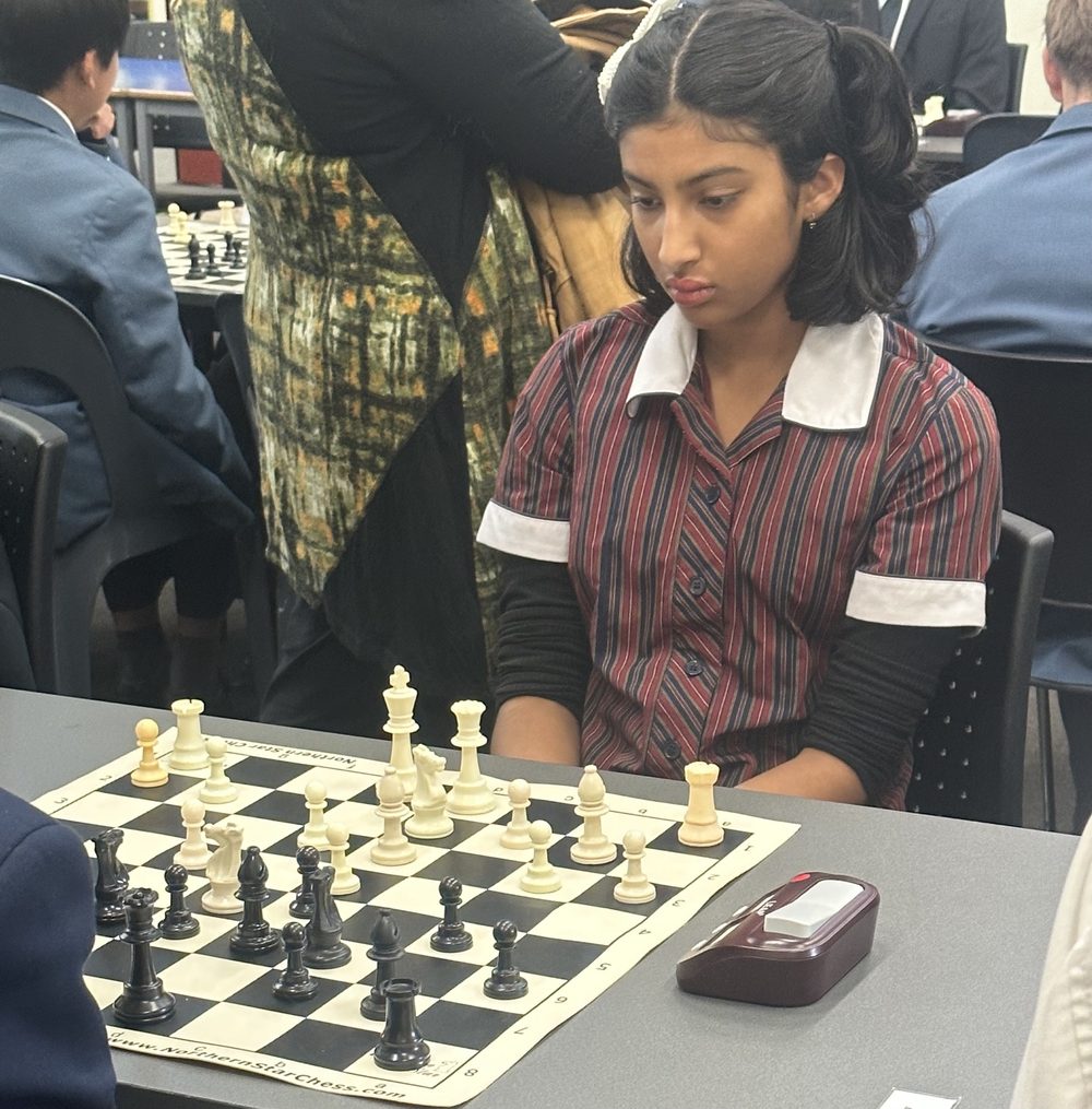 A focused student concentrating during a chess tournament game